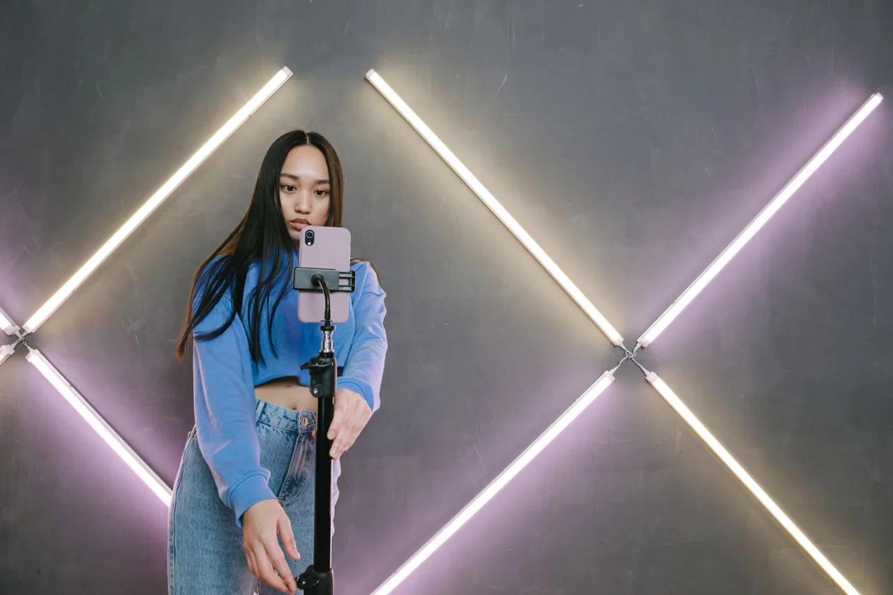 A creator setting up her phone on a tripod in front of studio lights, getting ready to go LIVE