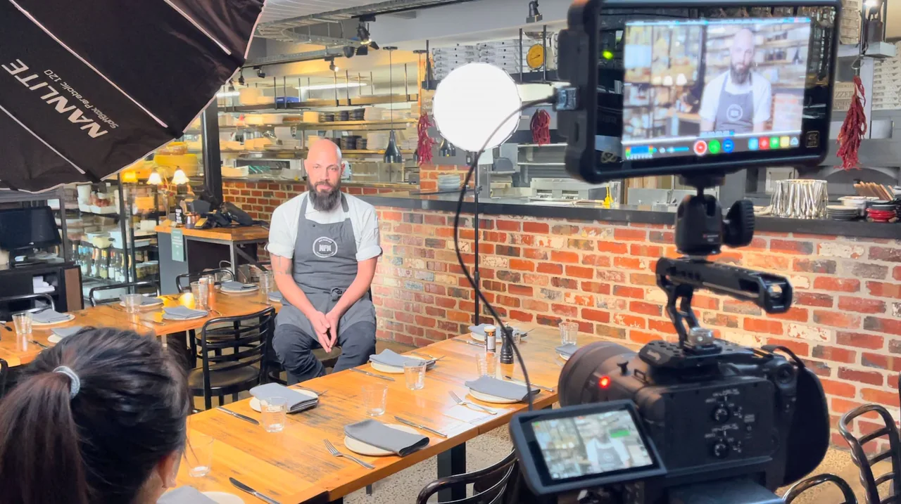 A camera filming a chef inside his restaurant during a video shoot